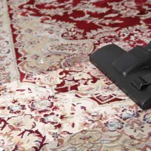 Hoovering carpet with vacuum cleaner, space for text. Clean trace on dirty surface